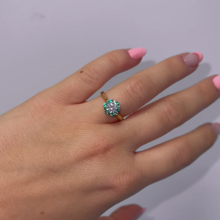 Video of model wearing sparkling round brilliant diamond ring with green halo and yellow gold band