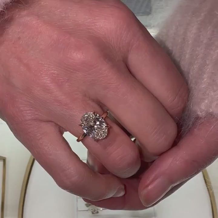 video of sparkling 4ct oval cut diamond with talon claws on models hand