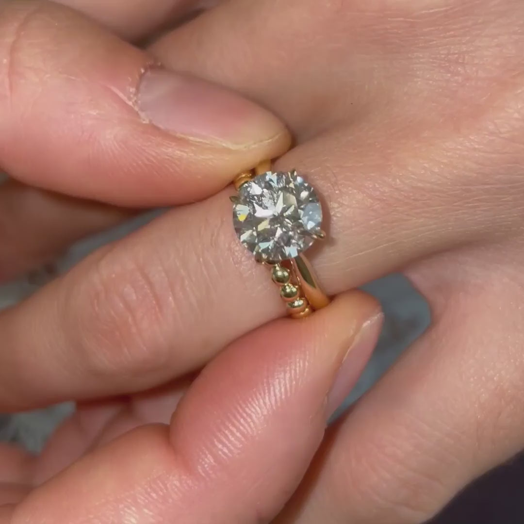 Video of model wearing solitaire tiffany classic diamond engagement ring in 18k gold with wedding band