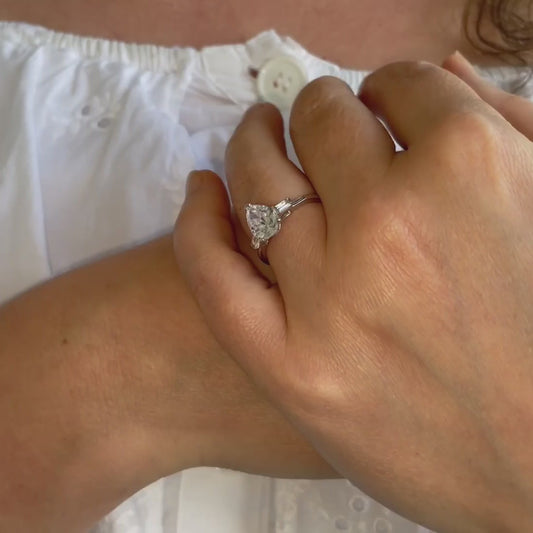 Video of model showcasing pear cut engagement ring with shoulder accents in platinum