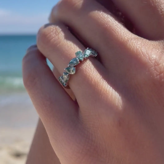 Close up of model's hand by the sea showing the Nova Seafoam with 9K white gold band