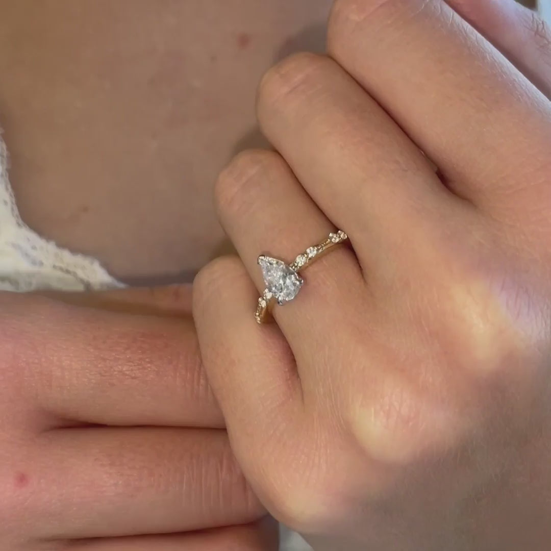 video close-up of The Hope Ring pear cut centre and shoulder-set diamonds