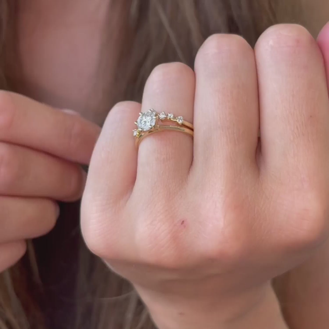 Women wearing bridal set of wedding band and engagement ring in yellow gold. a dainty solitaire single stone diamond ring